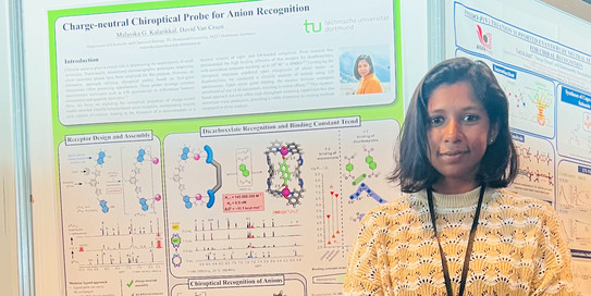 Malavika in front of her poster at the ISMSC 2023 conference.